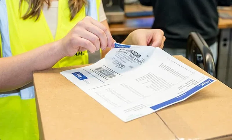 An image of an integrated form label combination with a worker peeling off the label.