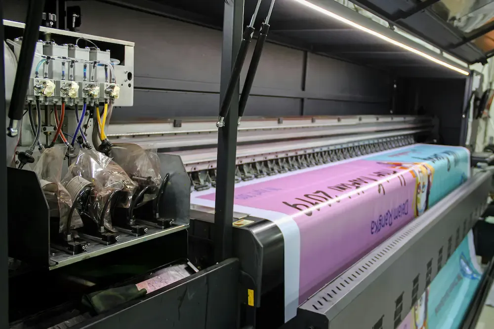 An image of a very large printer printing a poster for a business.